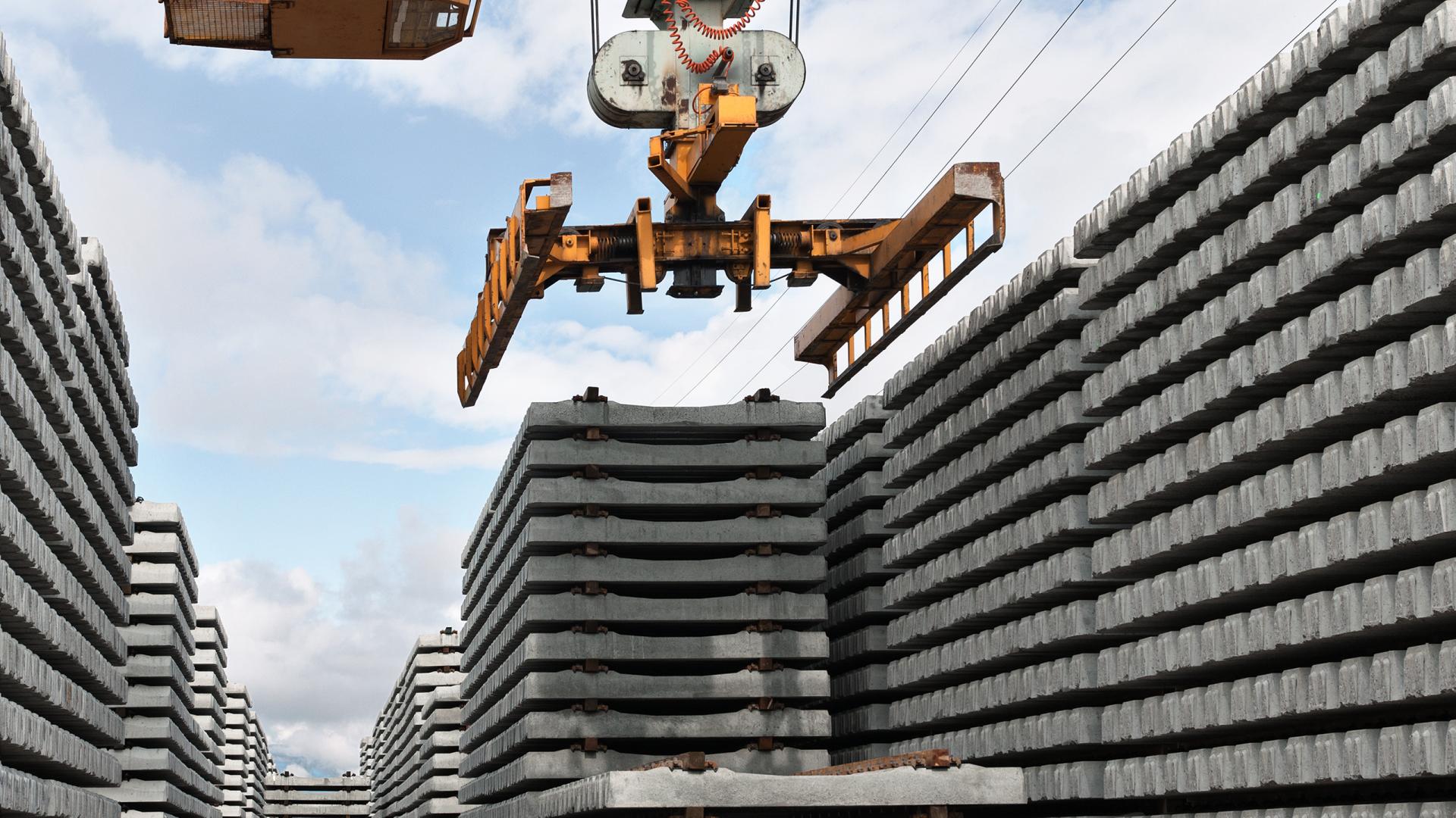 Beton Geleiseträger werden mit einem Kranen sortiert