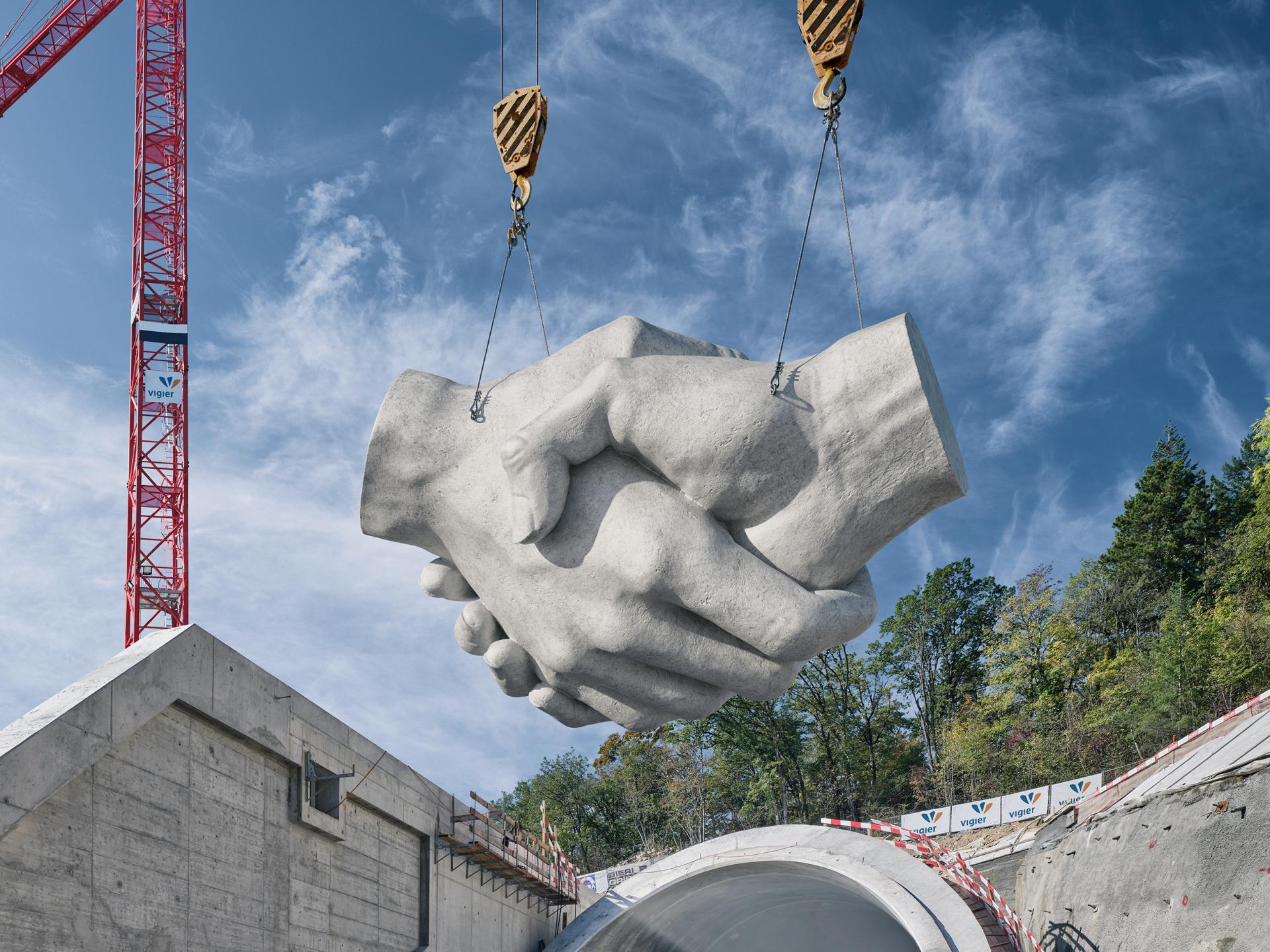 Das Keyvisual von Vigier MAnagaement zeigt eine Betonskulptur eines Handshakes. Sie wird von einem Kran angehoben.