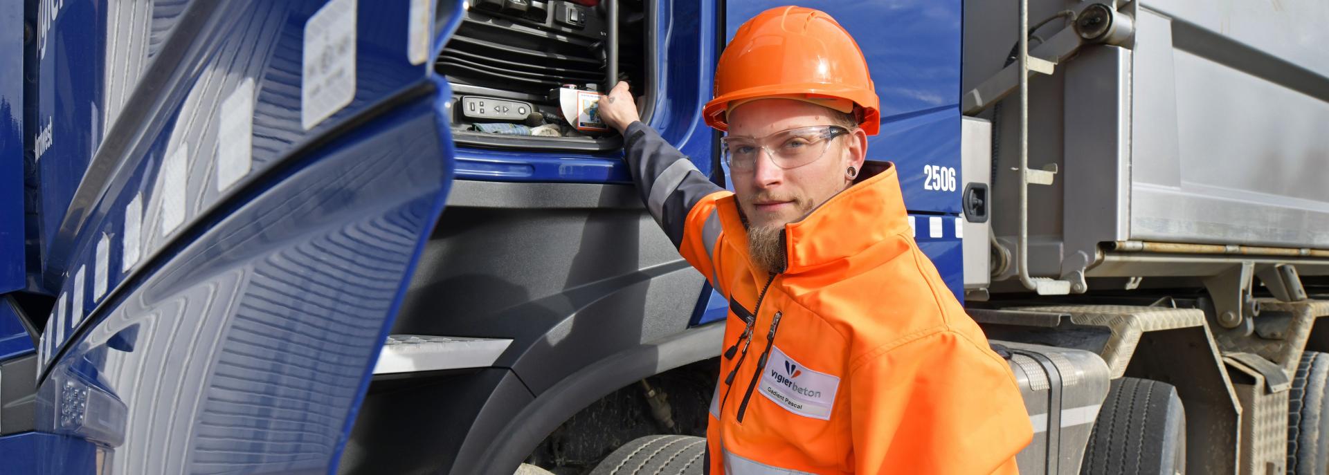 Ein Vigier-Lehrling steht in Sicherheitsausrüstung vor einem Vigier-LWK.